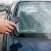 A man taking a picture of VIN from a car's dashboard.